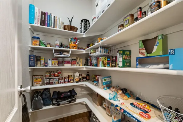 a utility room with stainless steel appliances lots of clutter and chairs