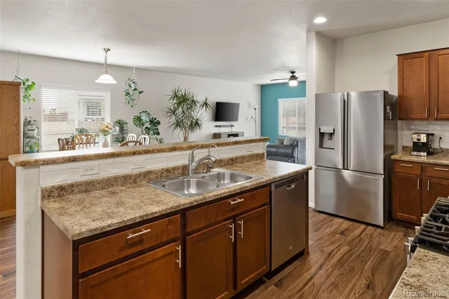 a kitchen with stainless steel appliances granite countertop a sink refrigerator and microwave