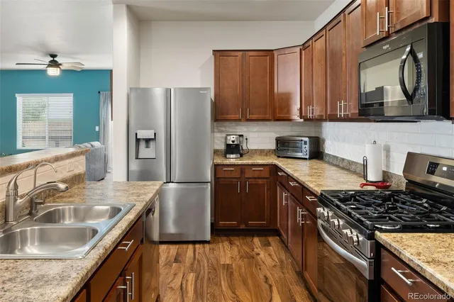 a kitchen with stainless steel appliances granite countertop a sink stove and refrigerator