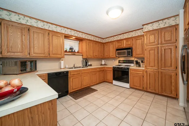 a kitchen with stainless steel appliances granite countertop a refrigerator and a stove top oven