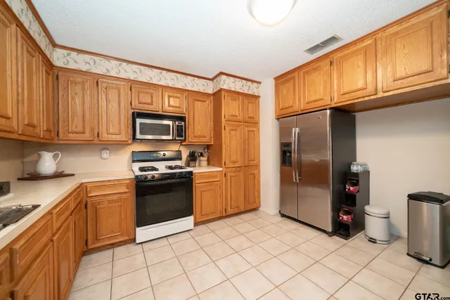 a kitchen with stainless steel appliances granite countertop a refrigerator and a sink
