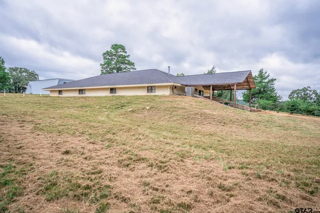 a backyard of a house with a yard and outdoor seating