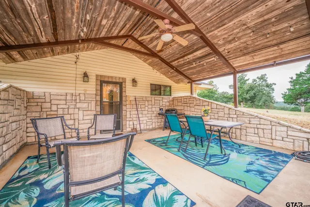 a view of a patio with a table chairs and backyard