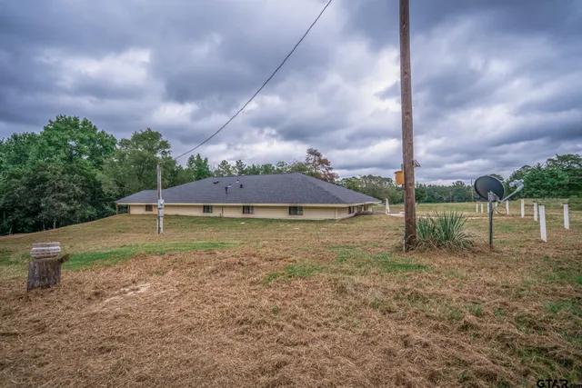 a view of a house with backyard and trees