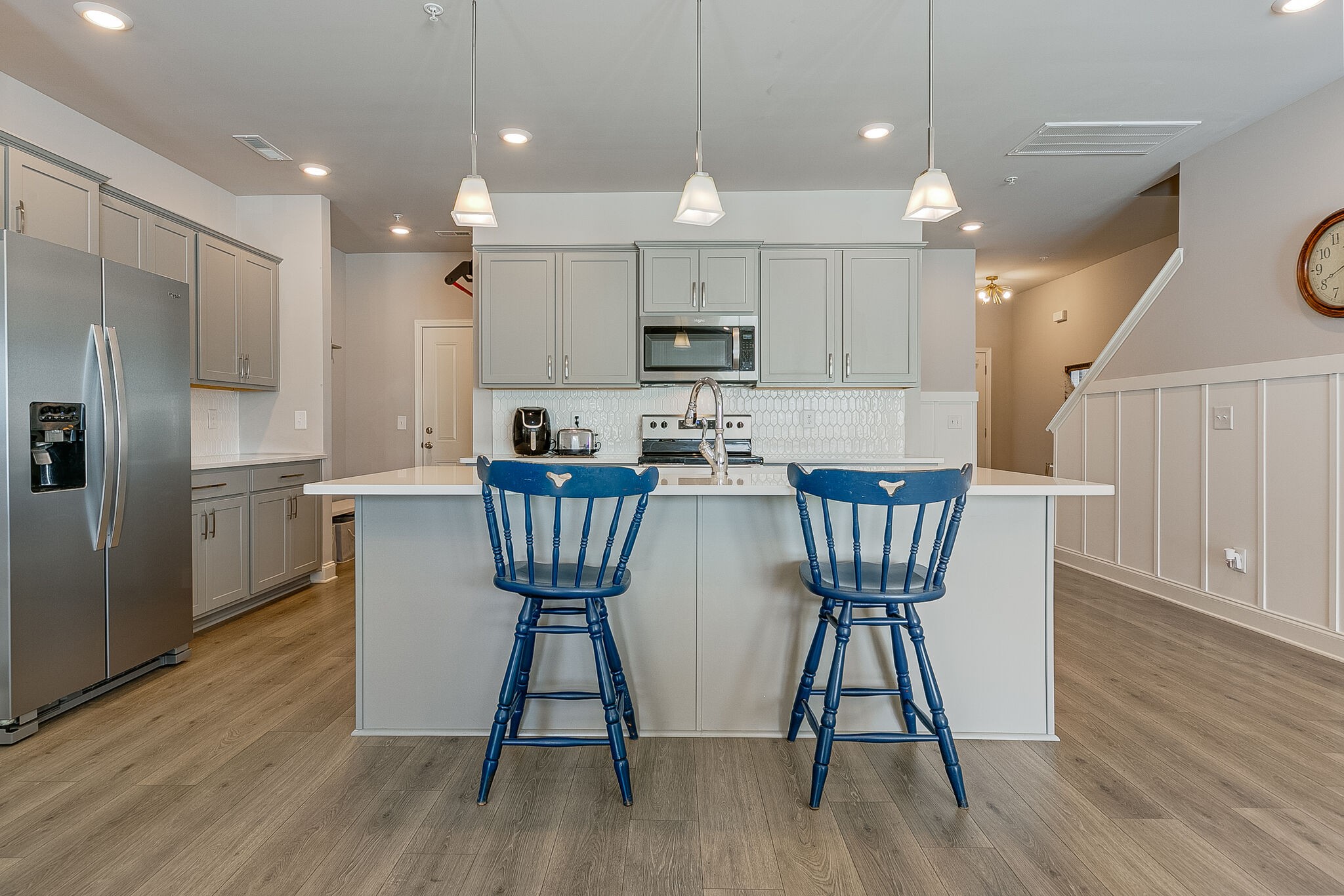1206 June Wilde Ridge Spring Hill, TN 37174 - Photo 11 of 43 a kitchen with stainless steel appliances granite countertop a dining table chairs wooden floors a large window and a refrigerator