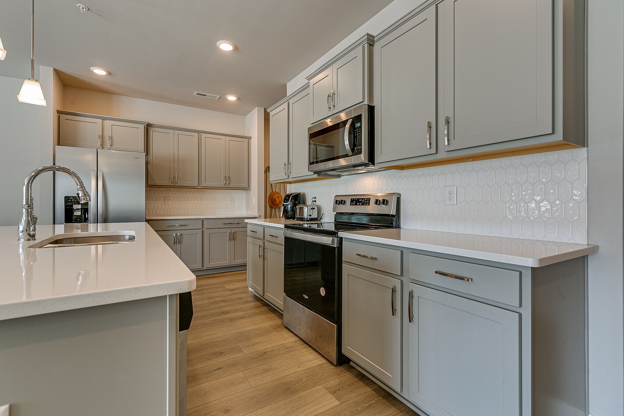 1206 June Wilde Ridge Spring Hill, TN 37174 - Photo 9 of 43 a kitchen with stainless steel appliances granite countertop a sink a stove a microwave a sink and cabinets