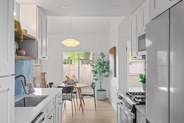 a bathroom with a sink a mirror and a potted plant