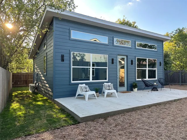 a kitchen with stainless steel appliances a dining table chairs and a refrigerator