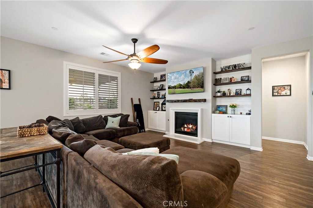30640 Lone Pine Drive Menifee, CA 92584 - Photo 20 of 48 a living room with furniture a fireplace and a flat screen tv