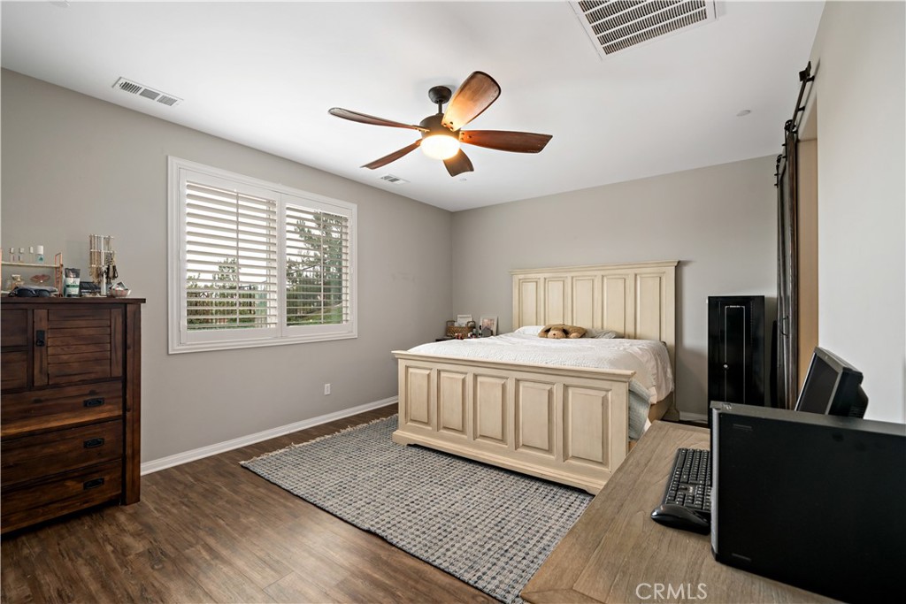 30640 Lone Pine Drive Menifee, CA 92584 - Photo 24 of 48 a bedroom with a bed and wooden floor