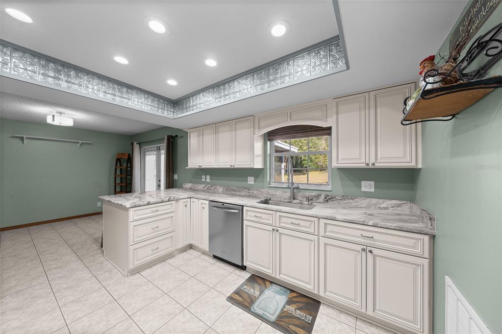 2645 Southeast 162nd Place Road Summerfield, FL 34491 - Photo 13 of 38 a kitchen with granite countertop white cabinets and white appliances