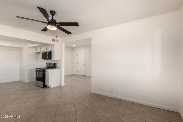 a kitchen with a refrigerator and white cabinets