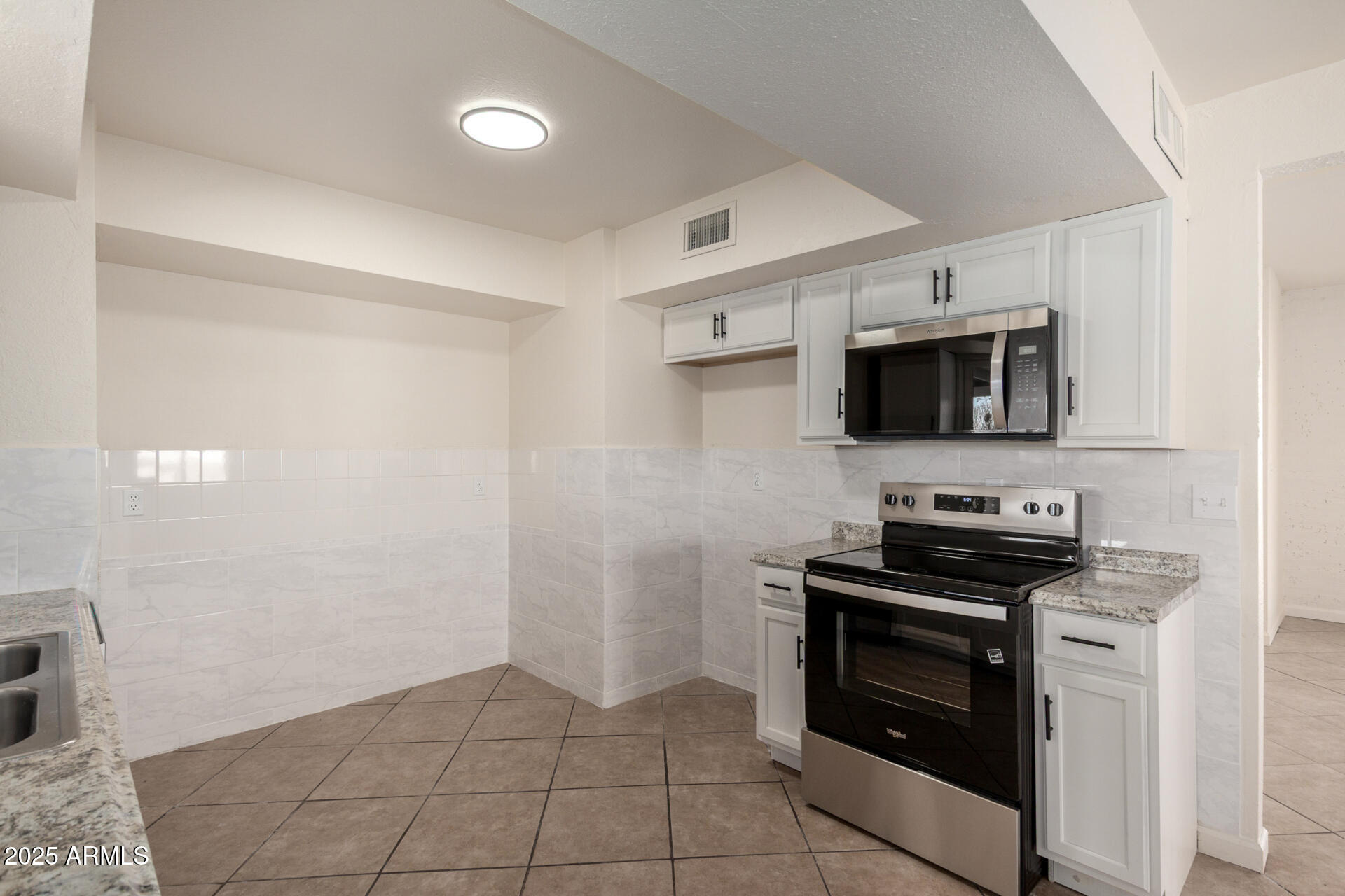 3613 East White Tail Road Pearce, AZ 85625 - Photo 13 of 39 a kitchen with stainless steel appliances a stove microwave and sink