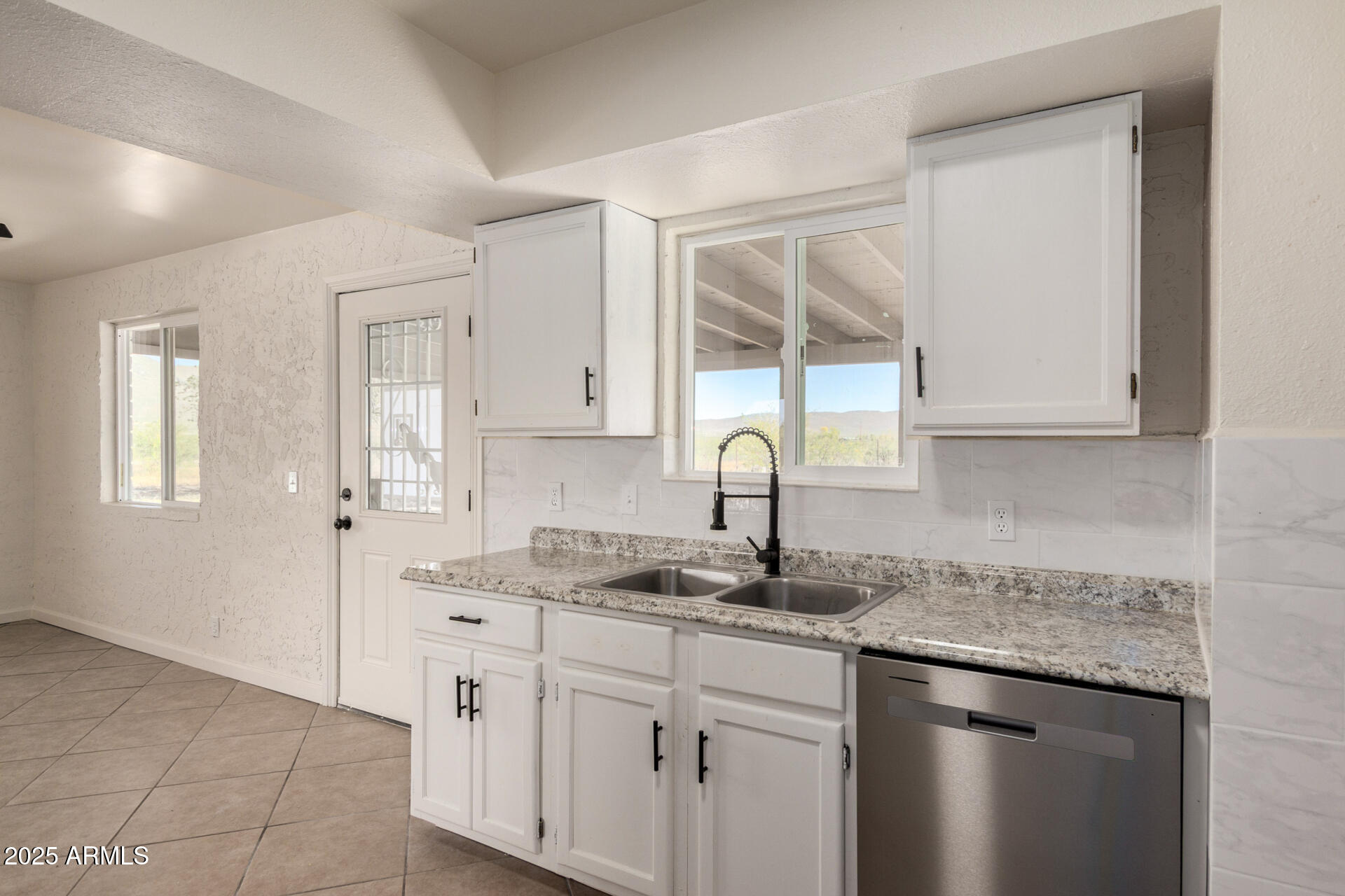 3613 East White Tail Road Pearce, AZ 85625 - Photo 14 of 39 a kitchen with stainless steel appliances granite countertop a sink and a white cabinets