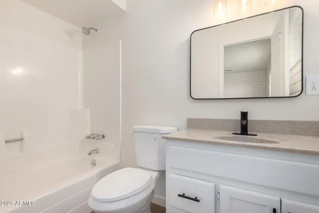 a bathroom with a toilet sink vanity and mirror