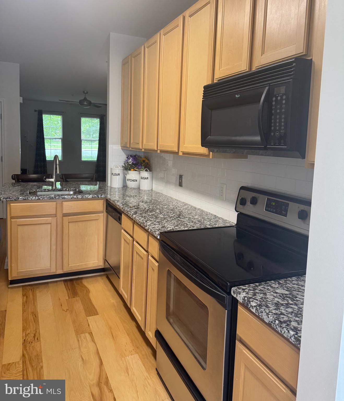 42429 Rockrose Square Brambleton, VA 20148 - Photo 3 of 13 a kitchen with stainless steel appliances granite countertop a sink stove and microwave