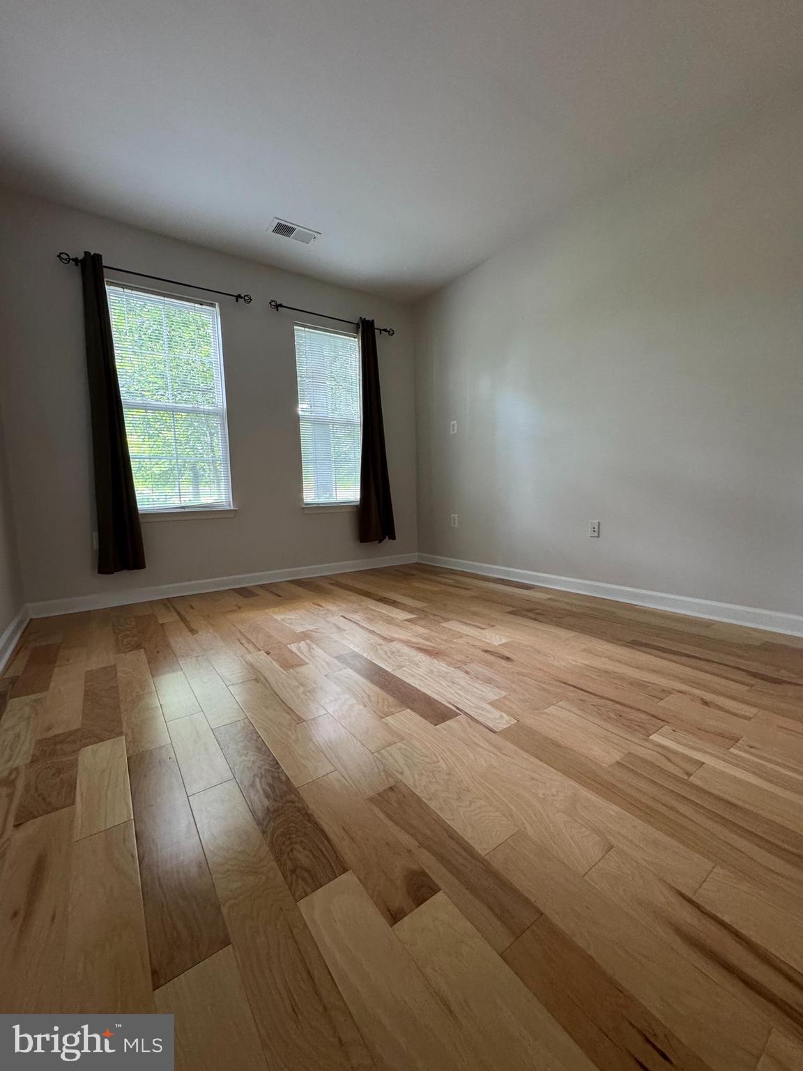 42429 Rockrose Square Brambleton, VA 20148 - Photo 9 of 13 an empty room with wooden floor and windows