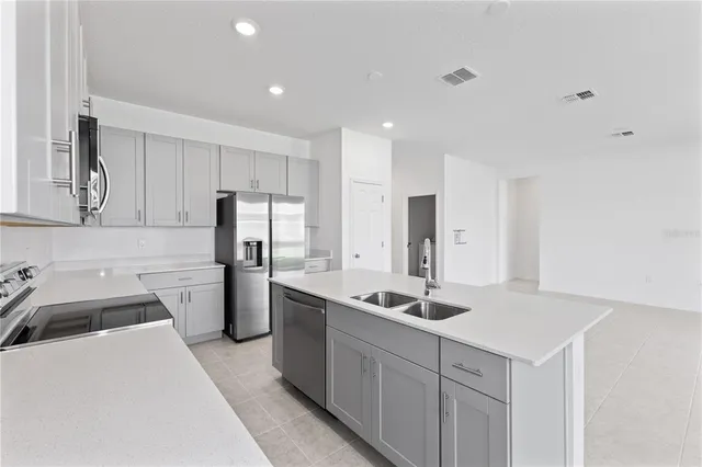 a kitchen that has a sink cabinets counter space and stainless steel appliances