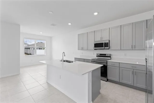 a kitchen with cabinets a sink a stove a microwave a counter top and cabinets