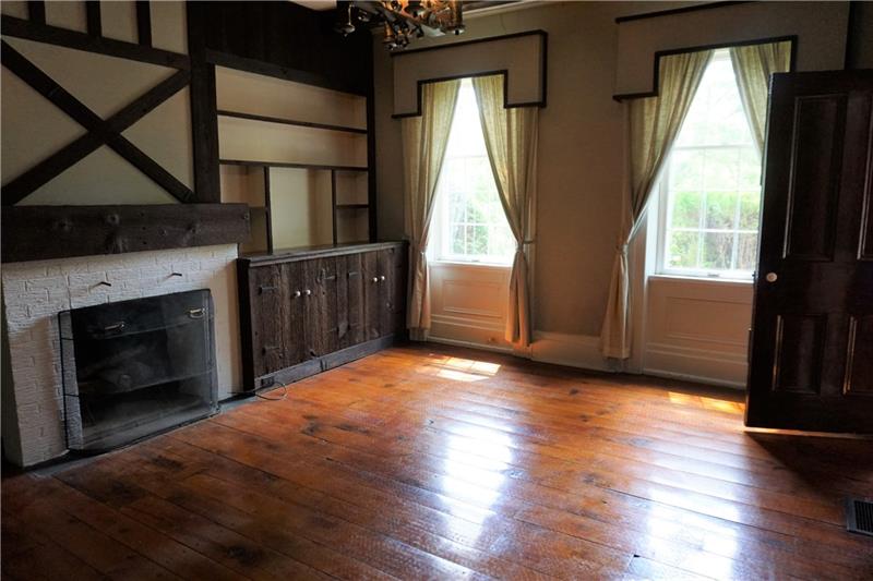 461 Lindsay Road Zelienople, PA 16063 - Photo 10 of 25 A brick fireplace, bright windows with custom window treatments, reclaimed wood from a barn on the property and stained glass are all highlights of this room.