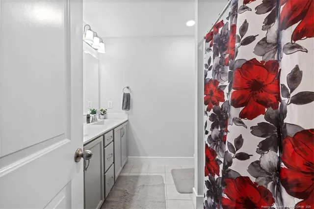 a bathroom with a sink and mirror with shower curtain
