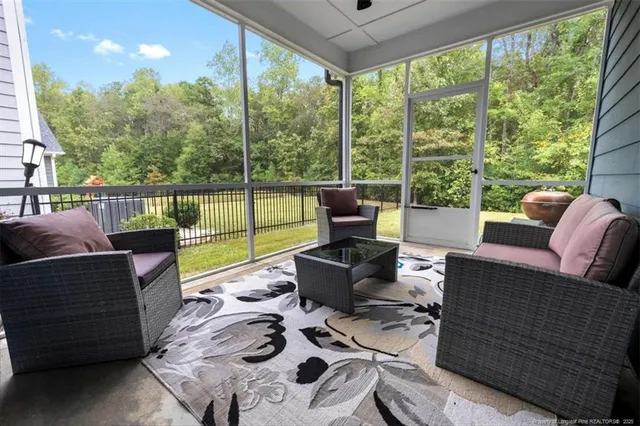 a living room with furniture and a floor to ceiling window