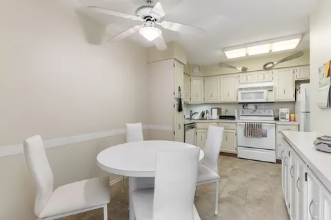 a kitchen with white cabinets and white appliances