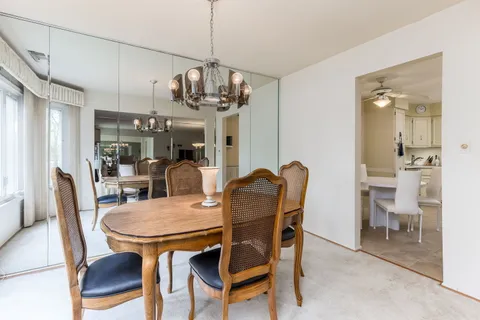 a view of a dining room with furniture a chandelier and wooden floor