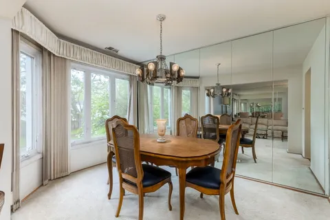 a dining room with furniture a chandelier and wooden floor