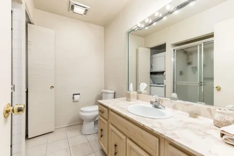 a bathroom with a granite countertop sink a toilet and a mirror