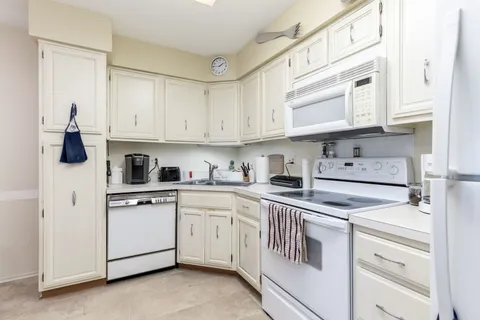 a kitchen with stainless steel appliances granite countertop white cabinets sink and dishwasher