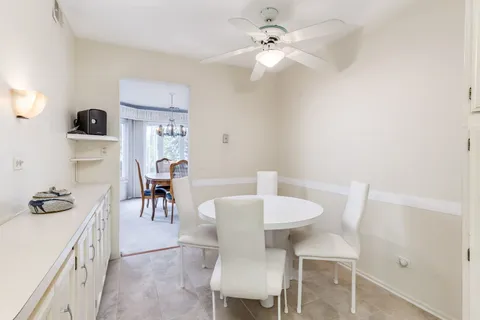 a view of a dining room with furniture and a chandelier fan