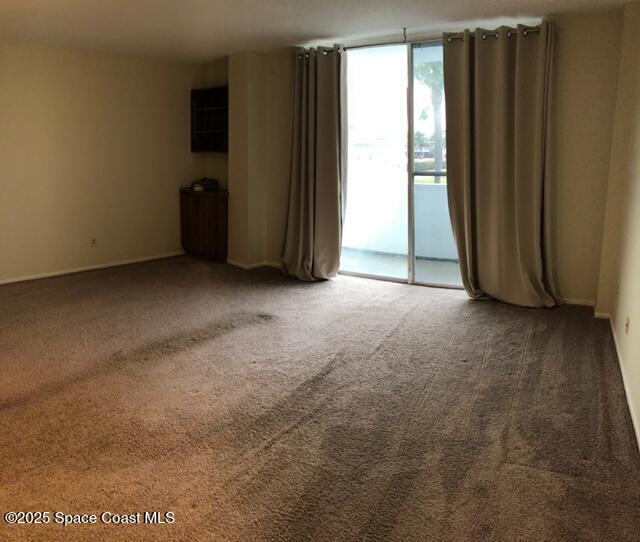 3190 North Atlantic Avenue, Unit 206 Cocoa Beach, FL 32931 - Photo 4 of 14 an empty room with windows