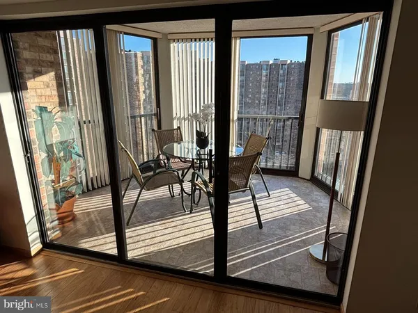 a view of a living room with a floor to ceiling window and wooden floor