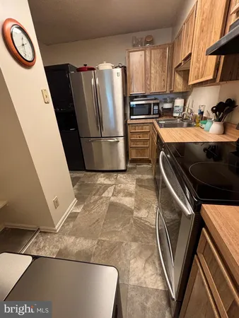 a kitchen with stainless steel appliances granite countertop a sink a stove a refrigerator and cabinets