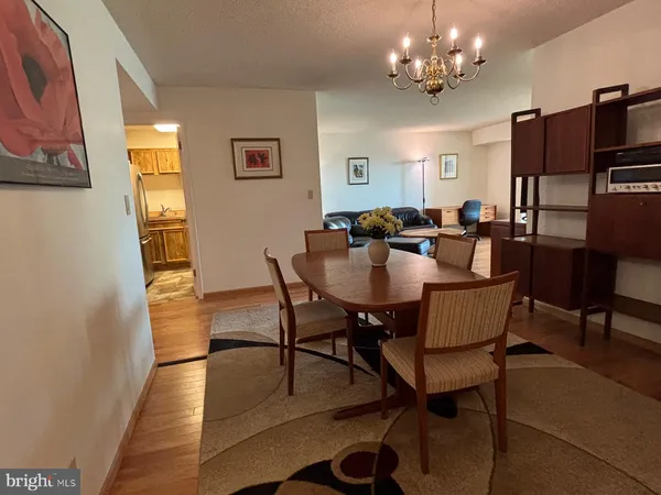a view of a dining room with furniture a chandelier and wooden floor
