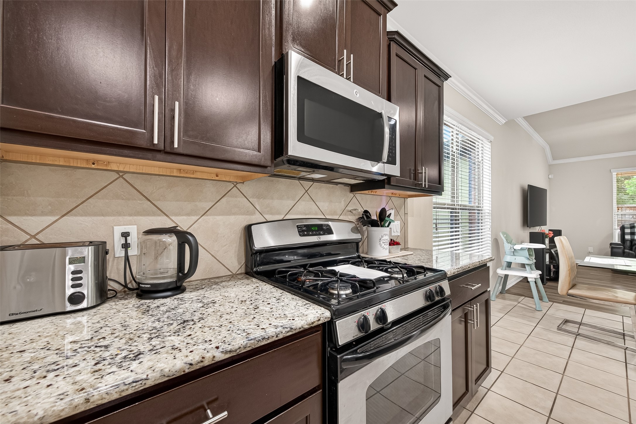 8 Landscape Court Conroe, TX 77301 - Photo 19 of 43 a kitchen with a stove and a microwave