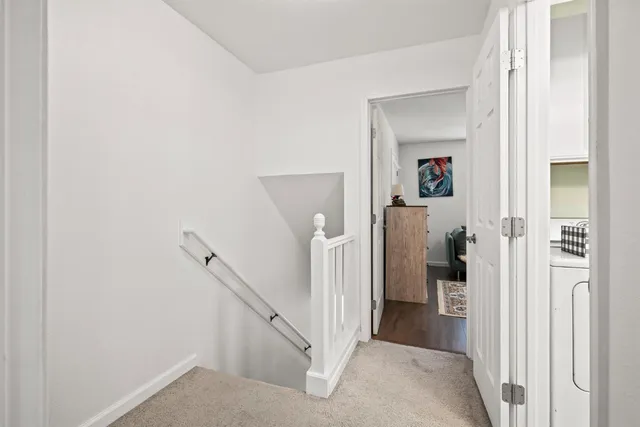 a view of a hallway with a furniture and a living room