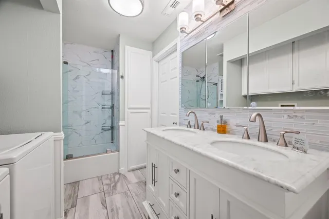 a bathroom with a sink a toilet and shower