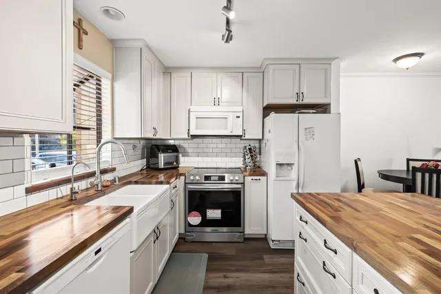 a kitchen with stainless steel appliances granite countertop a stove a sink and a refrigerator