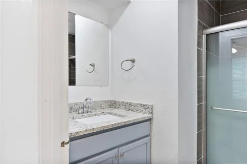 a bathroom with a granite countertop sink and a mirror