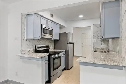 a kitchen with stainless steel appliances granite countertop a sink stove and refrigerator