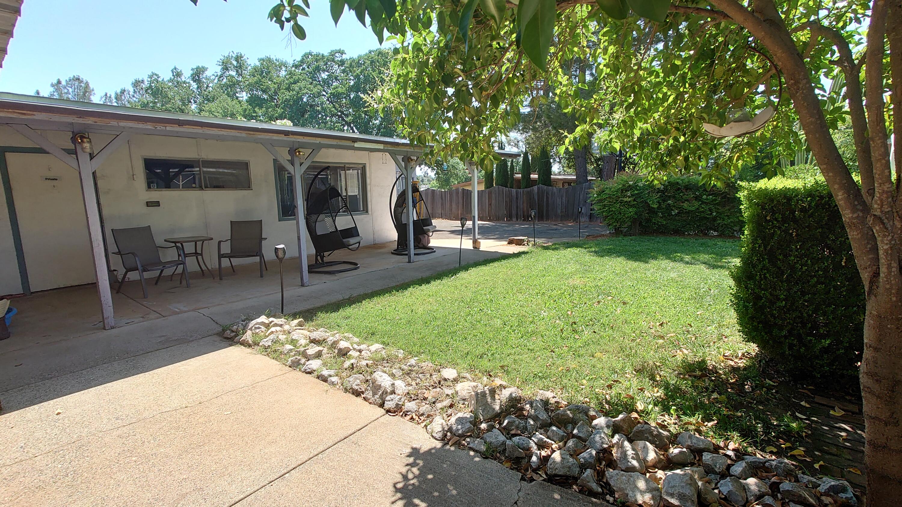 1713 Cascade Lane Redding, CA 96002 - Photo 12 of 12 a view of a patio with table and chairs potted plants and large tree