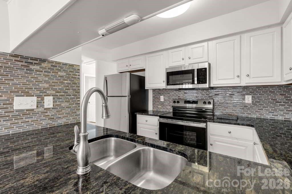 402 Sweetgum Drive Fort Mill, SC 29715 - Photo 4 of 10 a kitchen with granite countertop a sink stainless steel appliances and cabinets