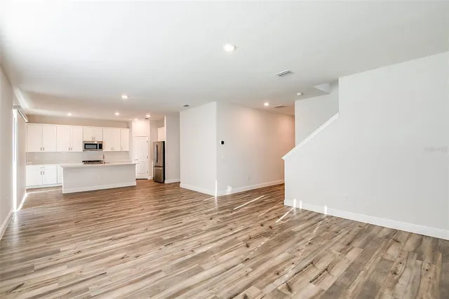a view of kitchen island wooden floor center island and stainless steel appliances