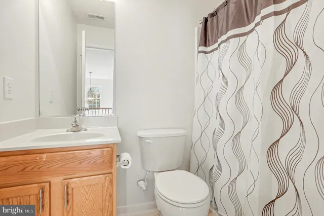 a bathroom with a granite countertop bathtub sink vanity mirror and toilet