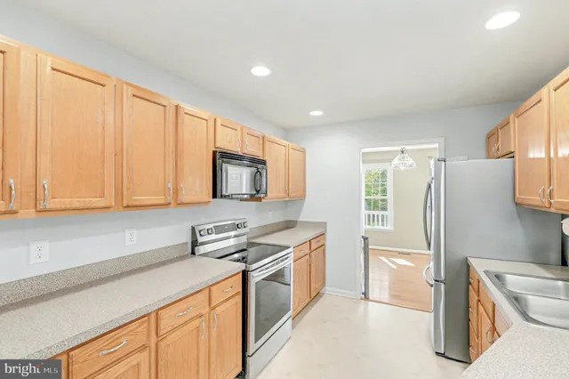a kitchen with stainless steel appliances granite countertop a refrigerator sink and stove