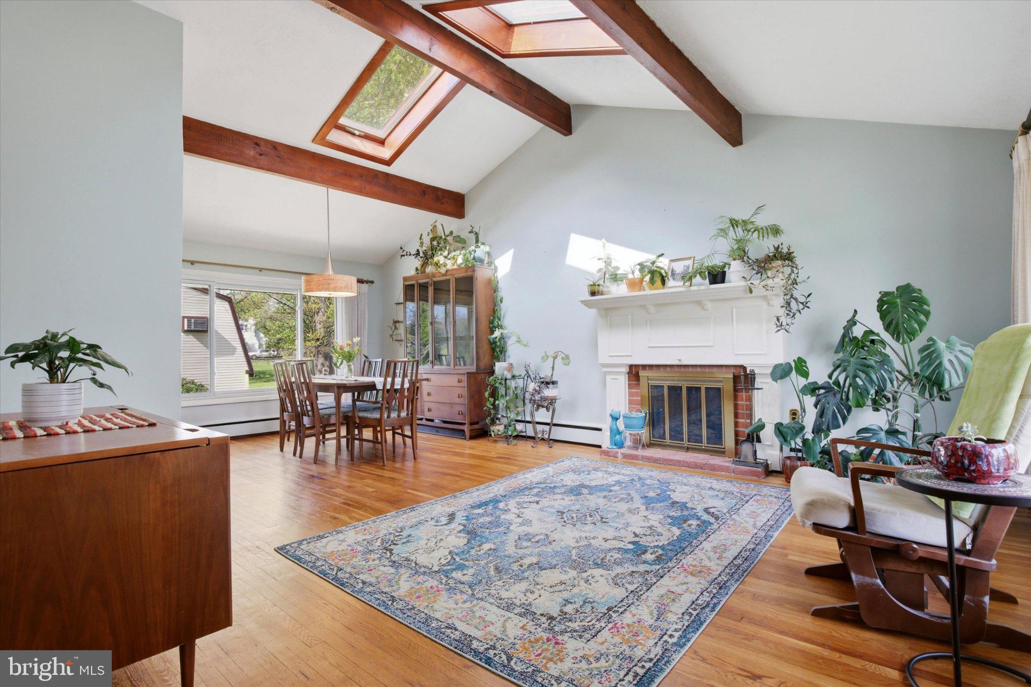 3386 Bristol Road Chalfont, PA 18914 - Photo 5 of 35 a living room with furniture a fireplace and potted plants with wooden floor