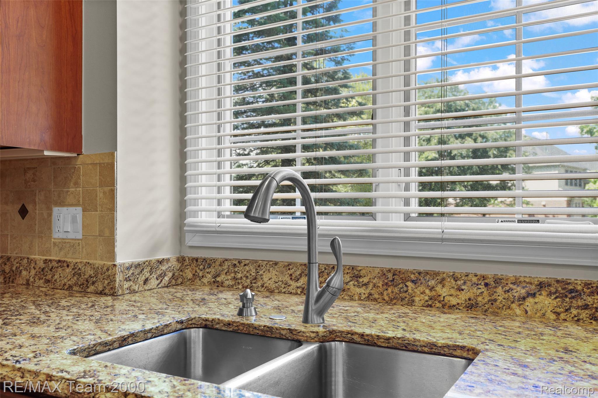 1248 Lasalle Road Canton, MI 48187 - Photo 32 of 67 Double basin stainless steel sink with a high-arc faucet, set into a speckled granite countertop