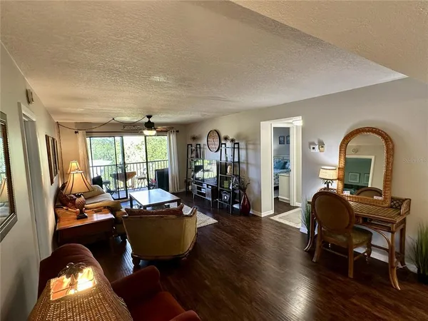 a living room with furniture a window and wooden floor